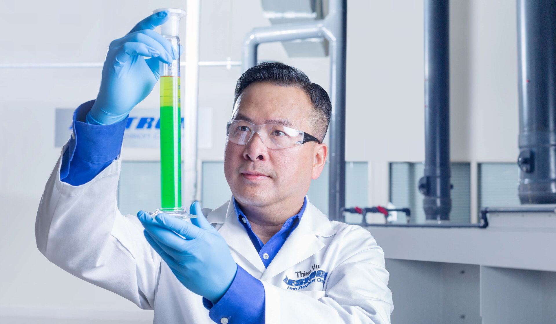 zestron engineer thein vu looking into test beaker with chemistry 