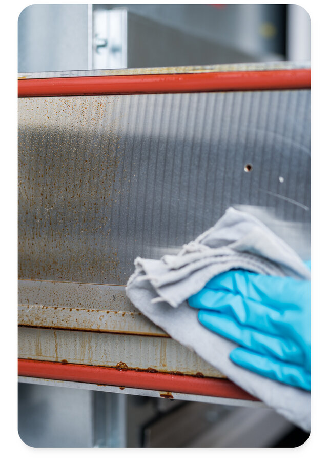 engineer wiping a reflow oven using zestron cleaning chemistry 