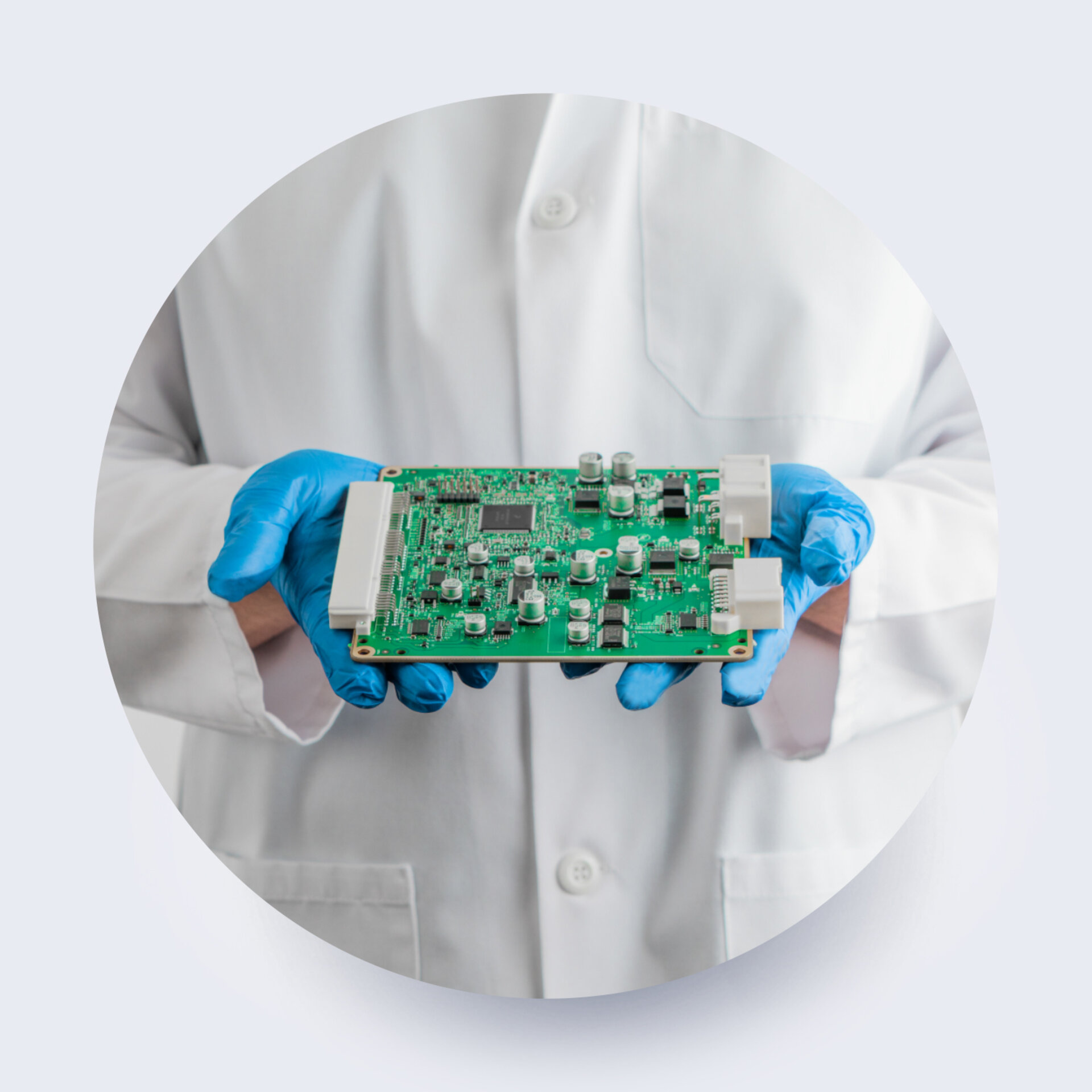 engineer holding a printed circuit board in lab coat 