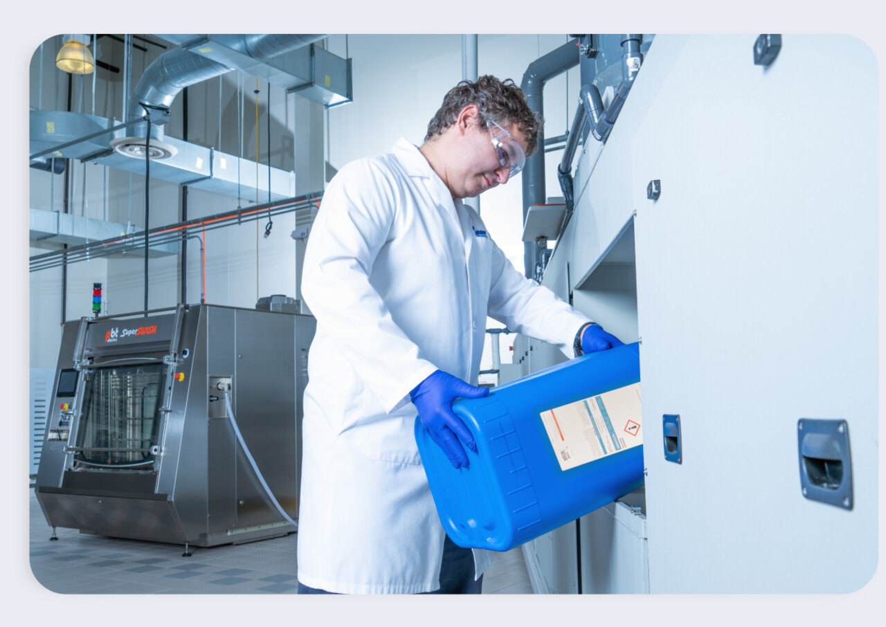 Terry price pouring ZESTRON chemistry into inline cleaning machine 